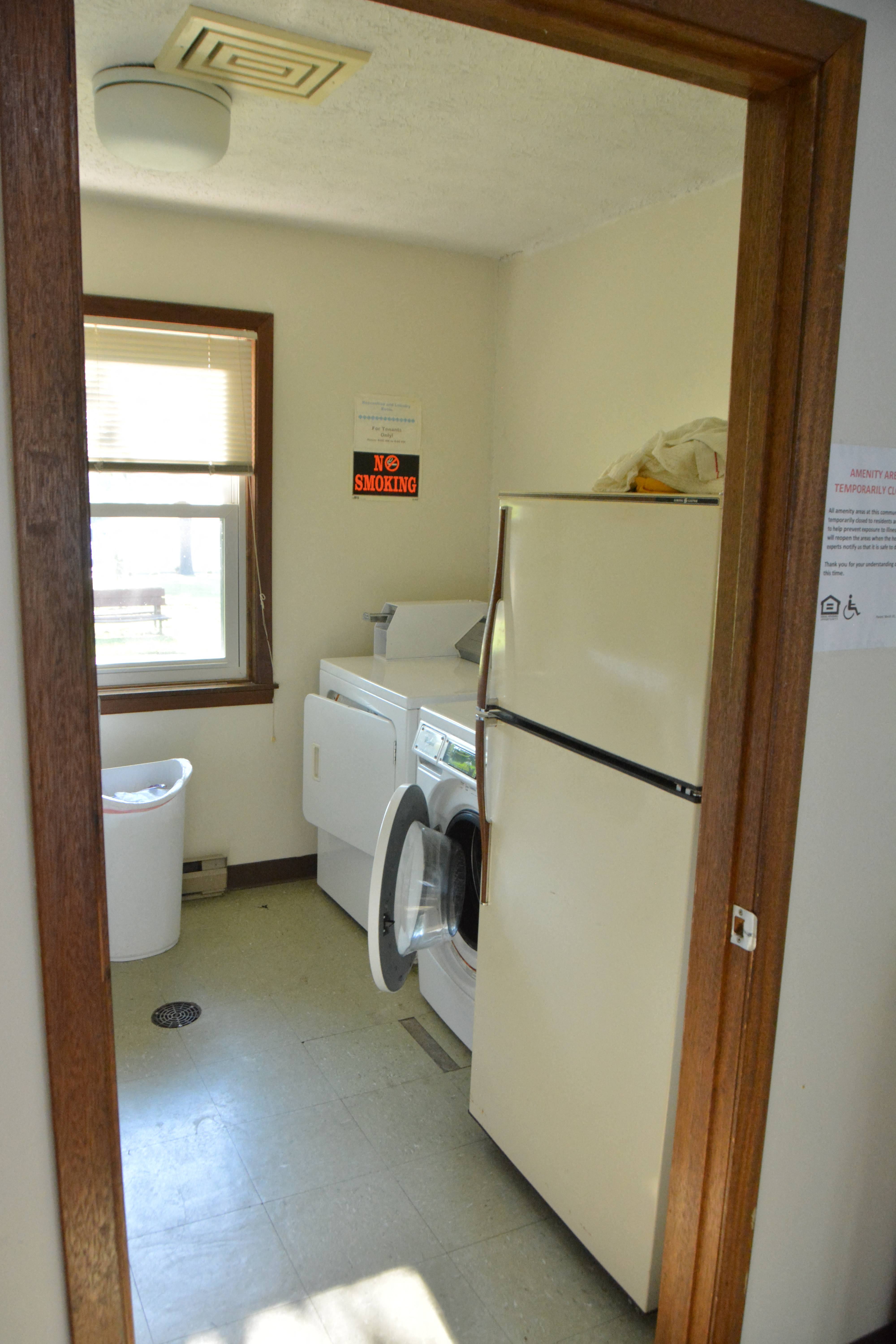 a laundry room with a refrigerator and a washing machine